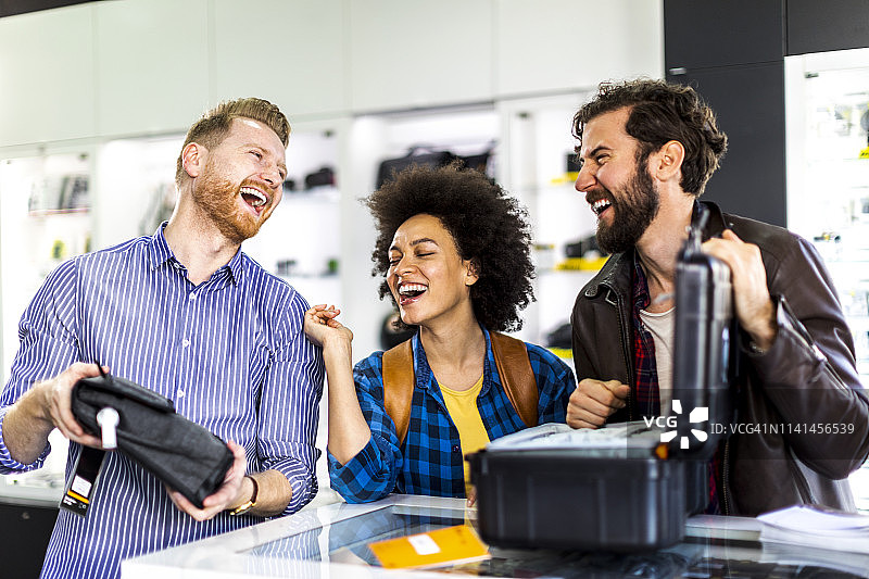 年轻顾客夫妇在相机店里比较相机包图片素材