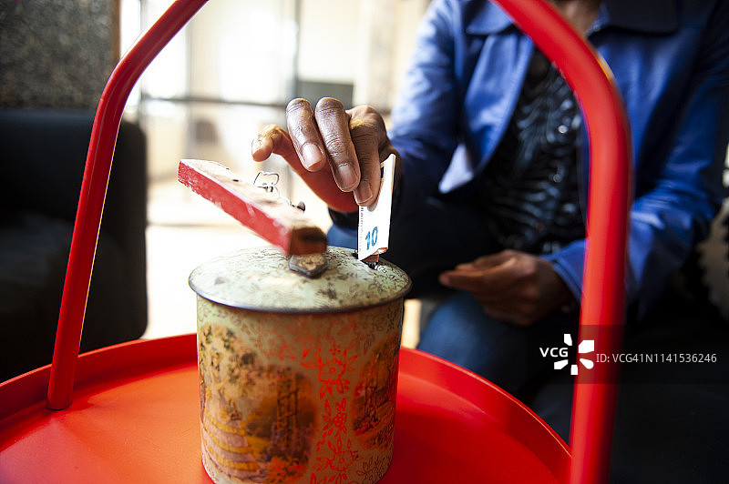 女人往储蓄罐里存钱图片素材