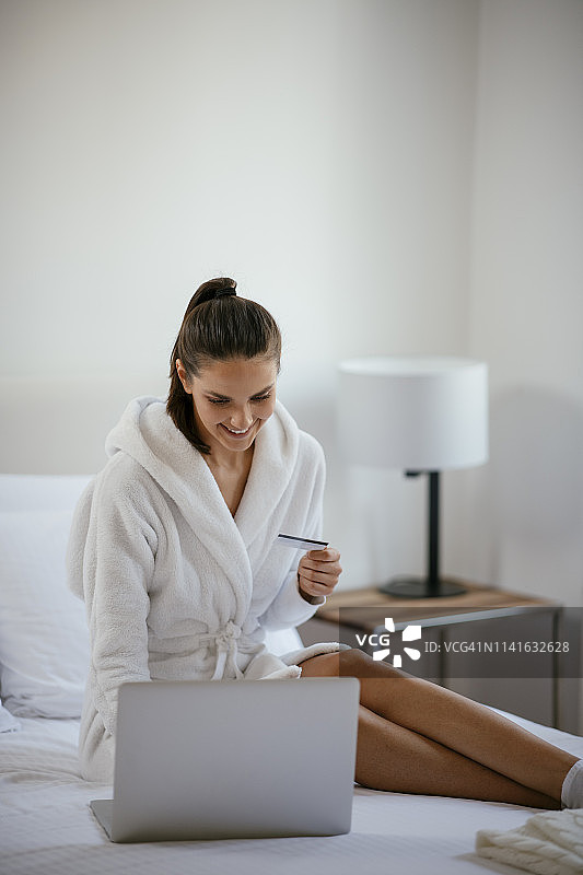 女人在卧室里用笔记本电脑网购图片素材
