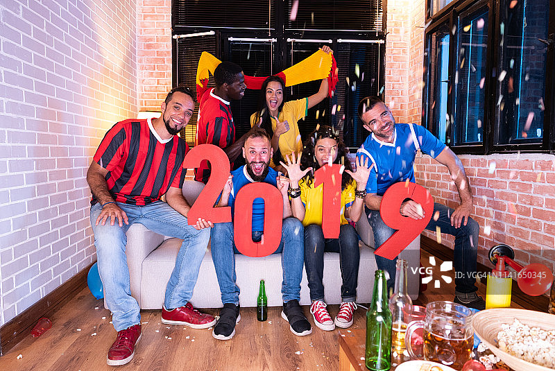 朋友们在看电视上的足球比赛图片素材