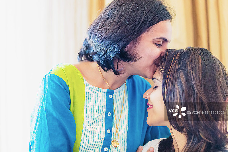 姐姐亲吻弟弟/妹妹的额头图片素材