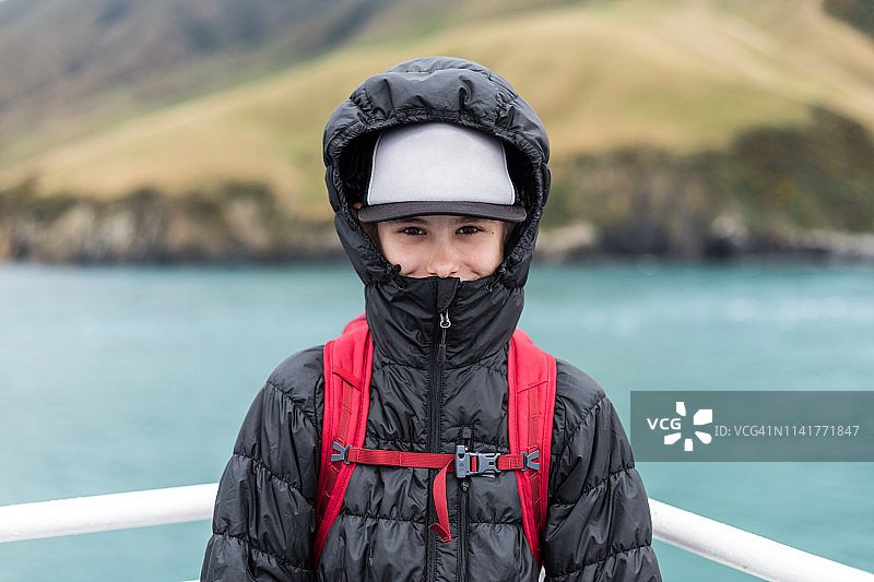 穿着带帽夹克的男孩在新西兰岛际渡轮上图片素材