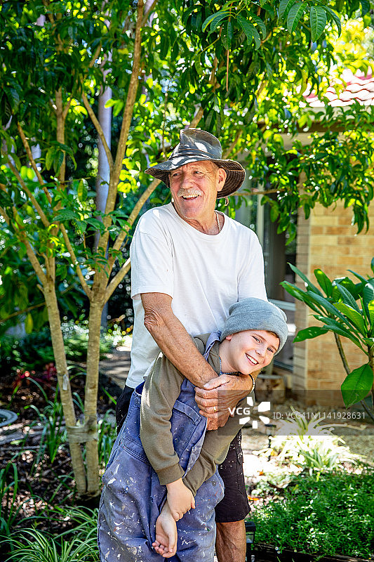 两个澳大利亚儿童与祖父在雨林后院玩耍图片素材