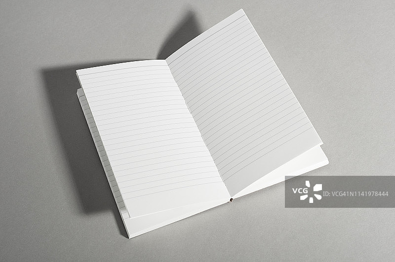 灰色背景上带有空白页面的打开的书本图片素材