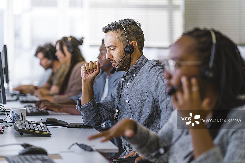 高管戴耳机倾听客户咨询图片素材