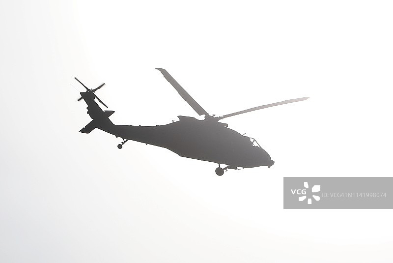 低角度仰望直升机白色天空下的剪影图片素材