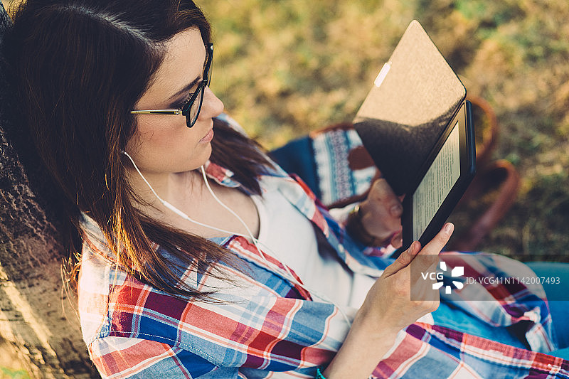 在公园阅读电子书的女子图片素材