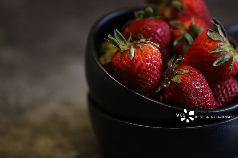 深色背景下的草莓特写图片素材