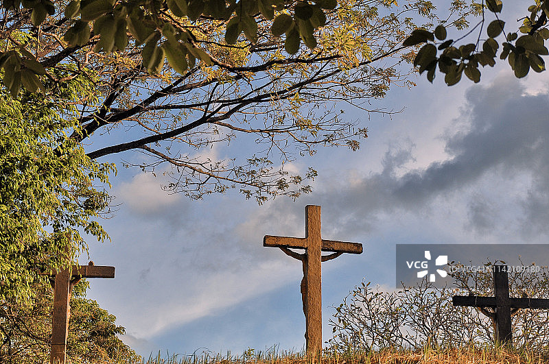 十字架上的耶稣基督，背景是天空和树木图片素材