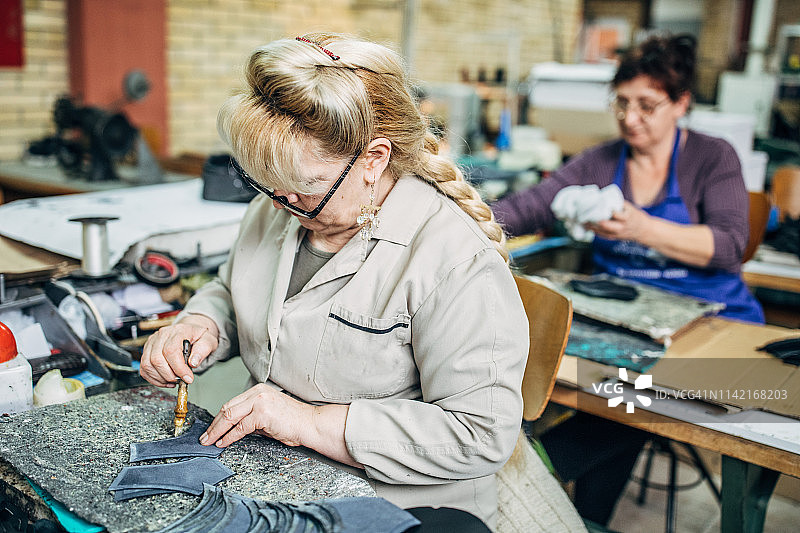 两个中年妇女在鞋厂工作图片素材