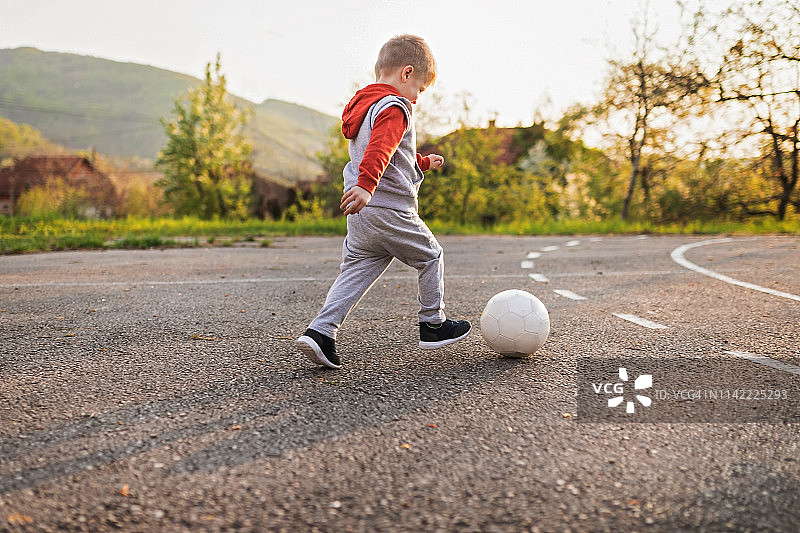 小男孩踢足球图片素材