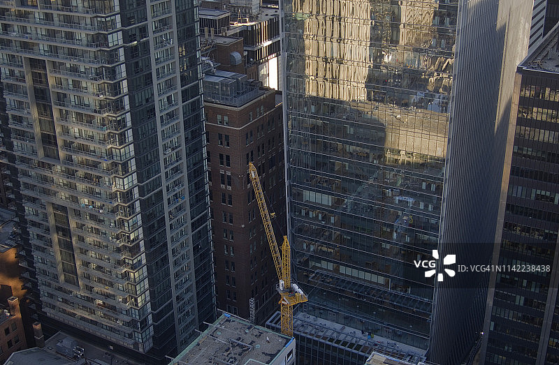 高楼林立的城市景观中的起重机图片素材