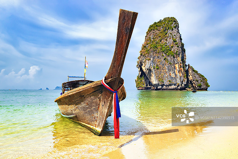 泰国甲米岛帕南海滩的长尾船和游客图片素材