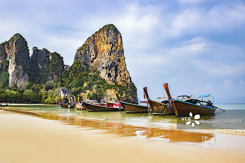 在泰国普吉岛莱利海滩乘坐长尾船的游客图片素材