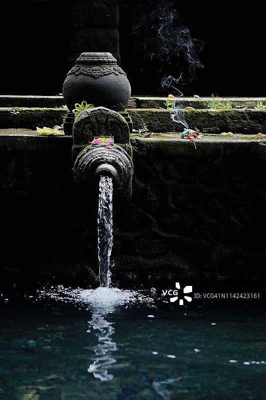 在印度尼西亚巴厘岛，人们在圣泉寺向圣泉供奉祭品图片素材