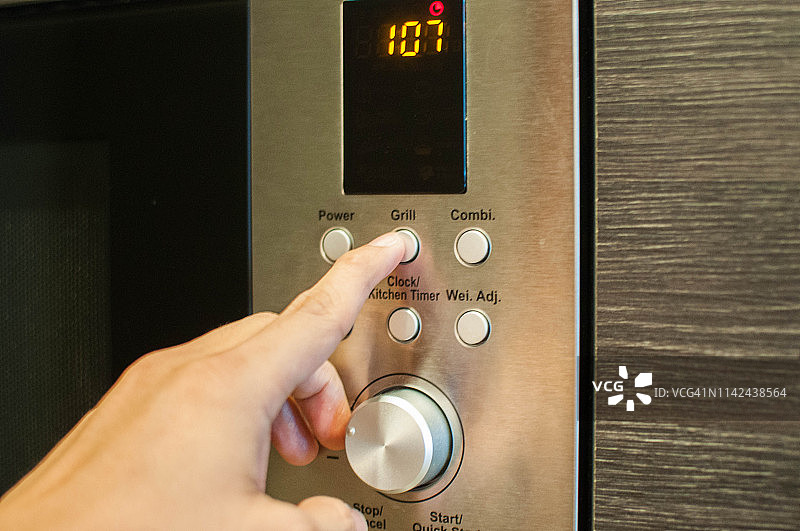 年轻人用电烤箱烹饪图片素材