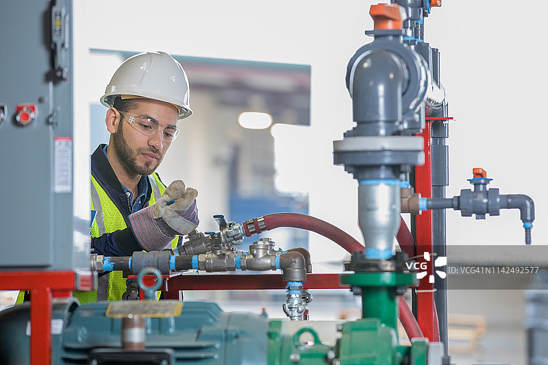 年轻的专业工程师在油气行业的作业现场操作设备图片素材