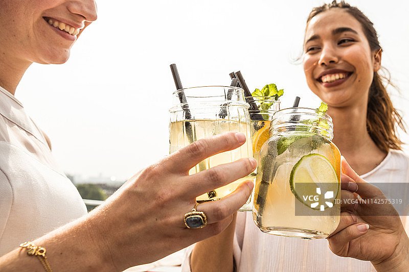 朋友们在阿姆斯特丹的屋顶酒吧喝新鲜莫吉托和鸡尾酒庆祝图片素材