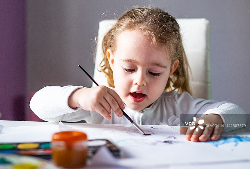 快乐的女婴用蛋彩画画图片素材