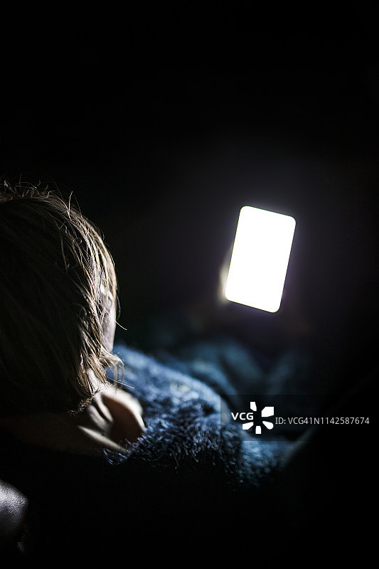 夜晚在家用智能手机的女人图片素材
