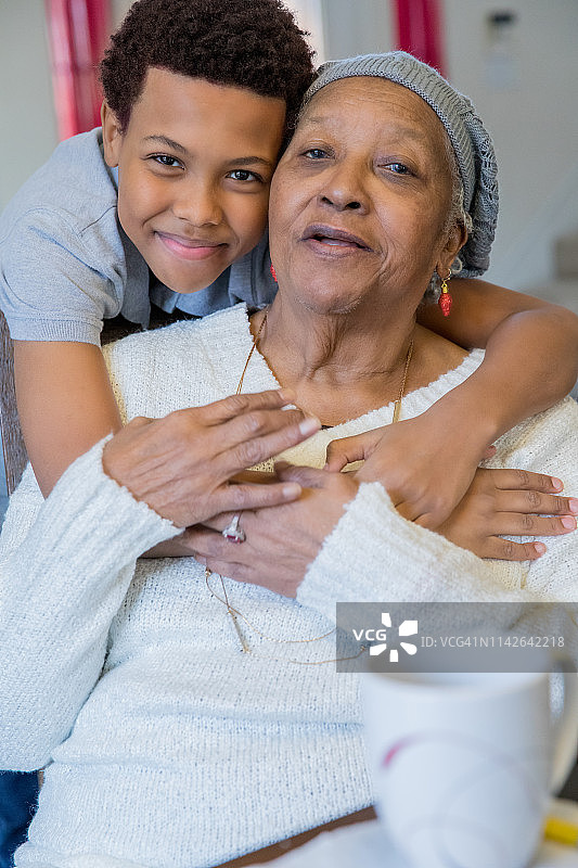 在疗养院探望期间，小男孩笑着拥抱年迈的曾祖母图片素材