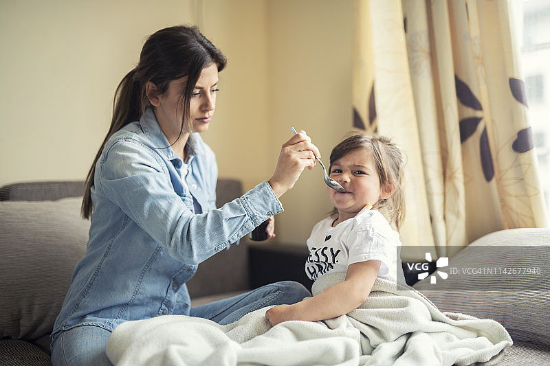 母亲给女儿喂药图片素材