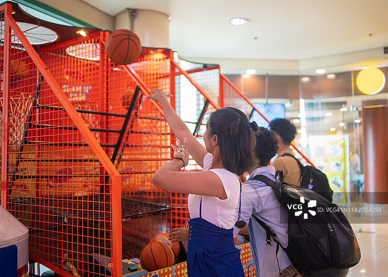 在游乐场玩篮球的多民族亚洲朋友图片素材