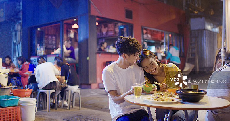 年轻情侣享受街头美食图片素材