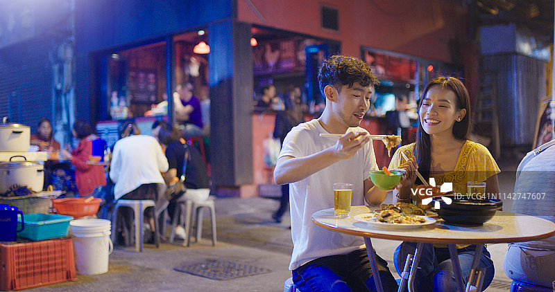 年轻情侣享受街头美食图片素材