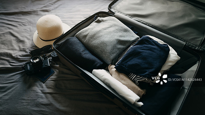装满旅行箱的床上个人物品高角度视图图片素材