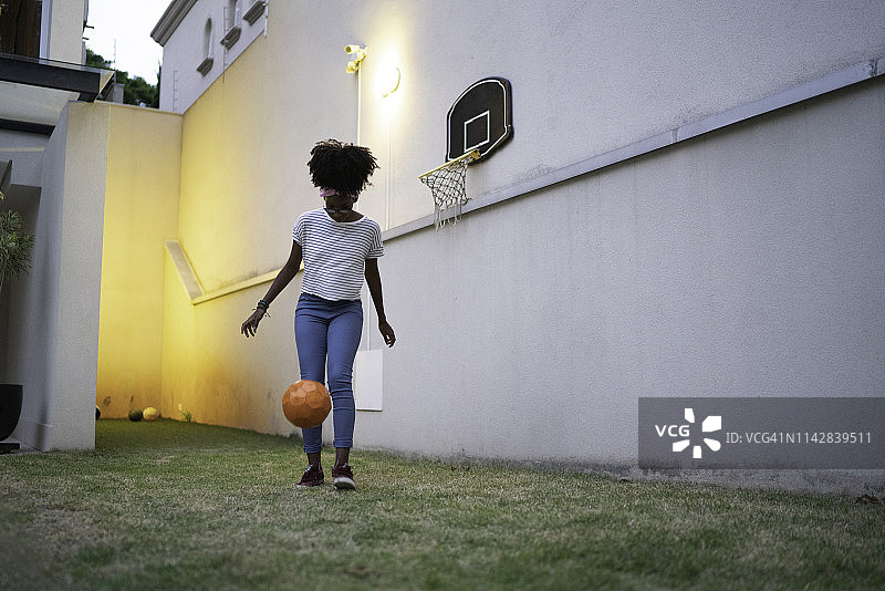 在后院踢球的少女图片素材
