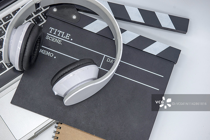 电影场记板电脑咖啡杯笔和记事本的办公室物品俯视图。黑暗效果图片素材