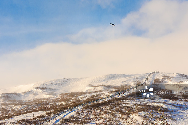 冬季攀爬管道，背景是直升机图片素材