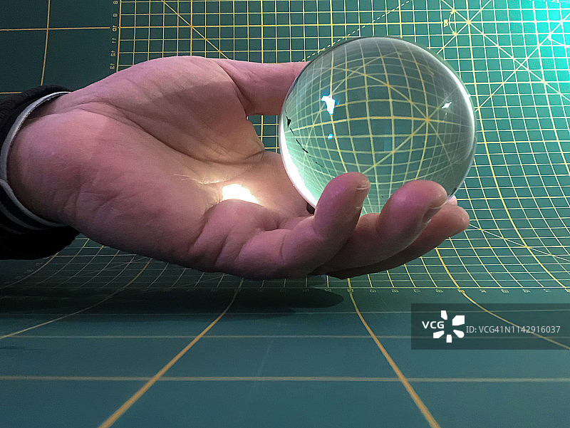 手持水晶球，置于切割垫前图片素材