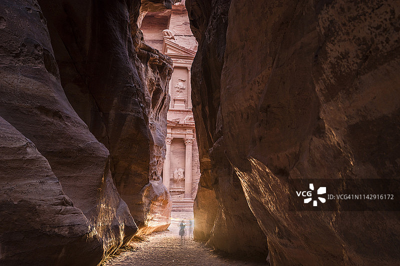 两人站在约旦佩特拉古城峡谷中图片素材