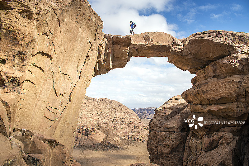 男子走过约旦瓦迪拉姆的石桥图片素材