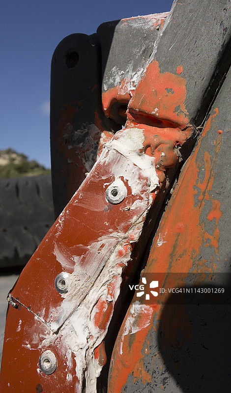 铆接在生锈金属上的金属板补丁，涂有丙烯酸密封剂和防锈底漆图片素材