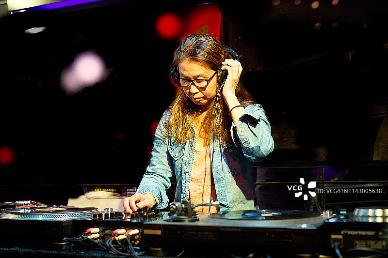在夜总会派对上播放音乐的DJ半身照图片素材