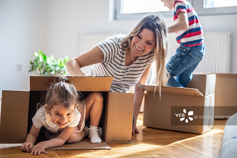 快乐的兄弟姐妹在新家的盒子里玩耍图片素材