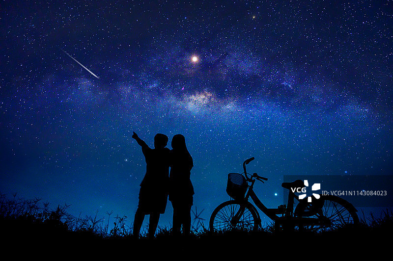 在蓝色星系之夜仰望星空的恋人图片素材