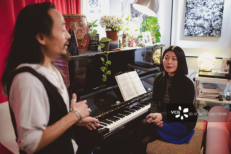 女声乐老师向男人讲解唱歌技巧图片素材