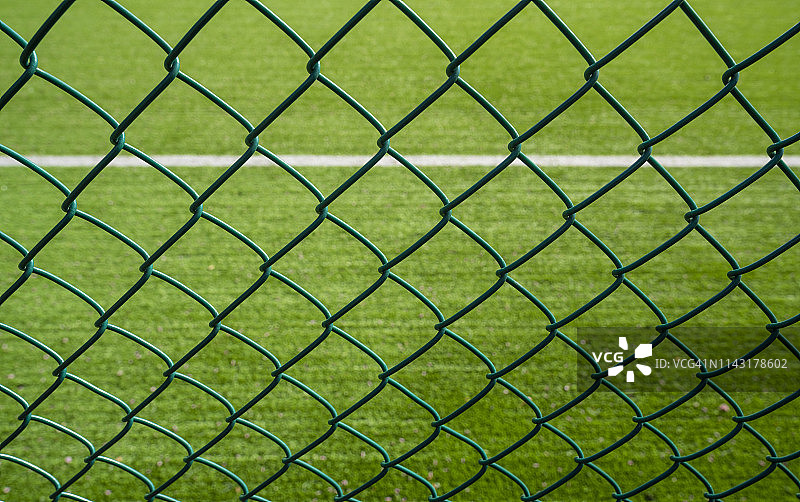 带刺铁丝网外的足球场图片素材