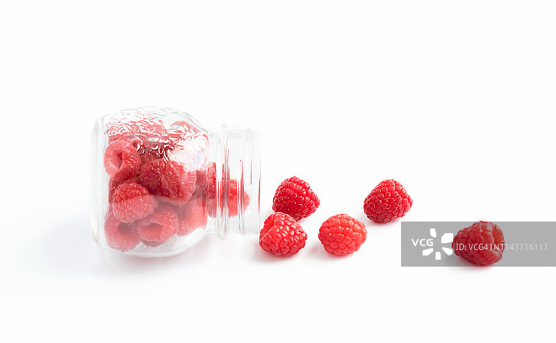 装满红色成熟覆盆子的透明罐子图片素材