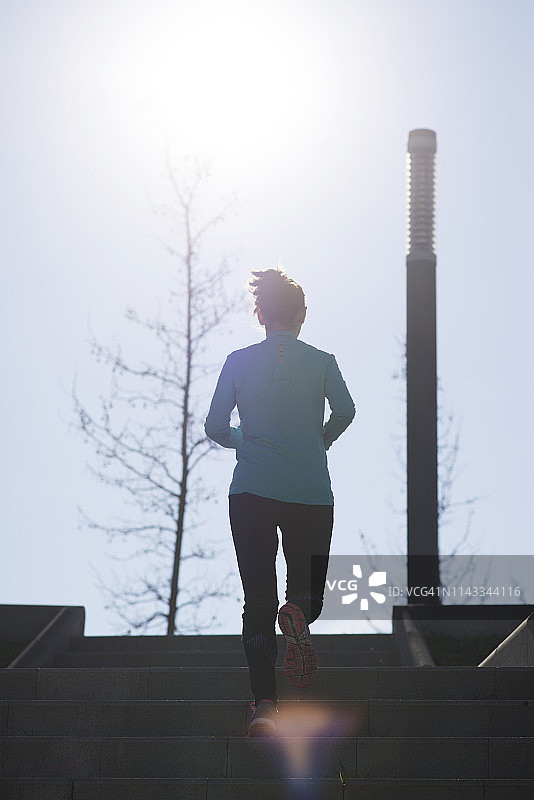 晴天，女子在公园走上台阶的背影图片素材