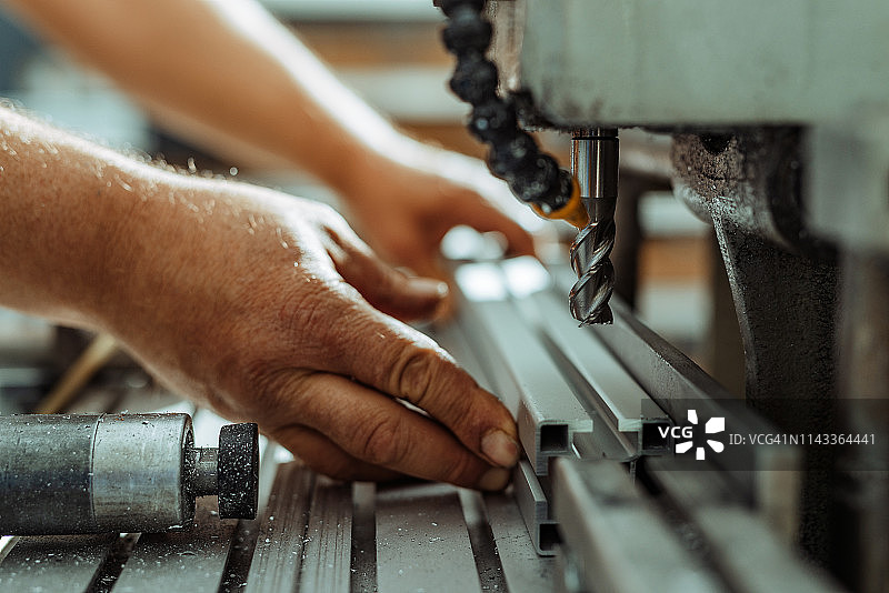 在金属切割机和钻床上工作的产业工人图片素材
