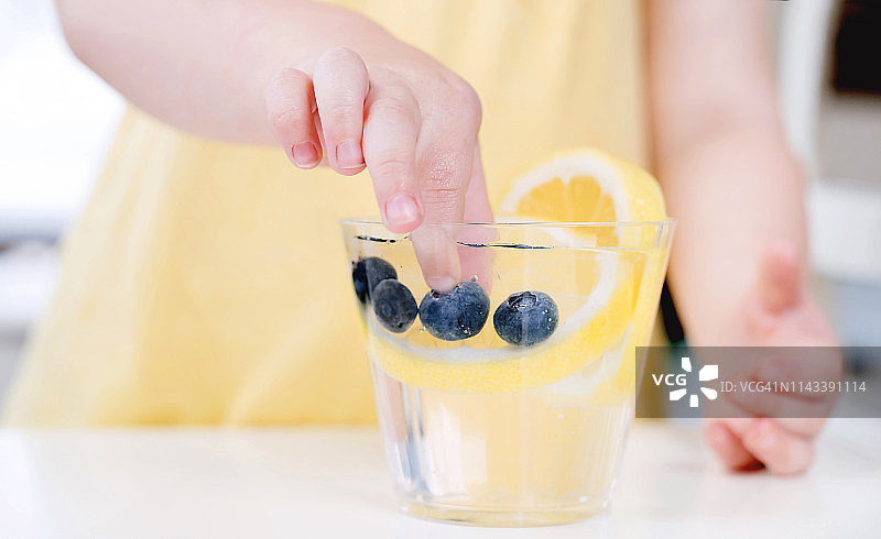 幼儿用手从水中捞水果图片素材