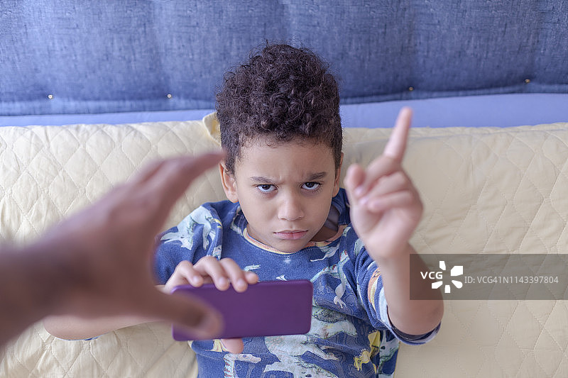 家庭矛盾中，父亲试图从不听话的儿子手中拿走手机图片素材