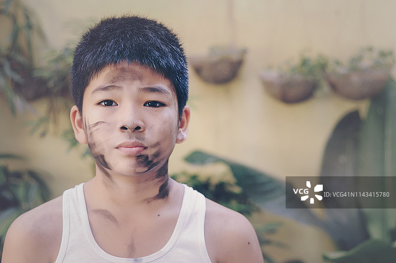 脸上涂有木炭污迹的男孩图片素材
