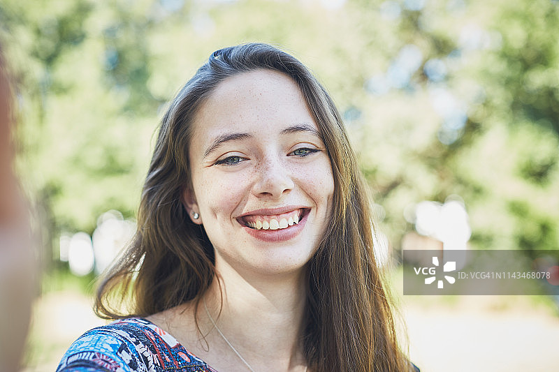 公园里美丽的微笑年轻棕发女子肖像图片素材
