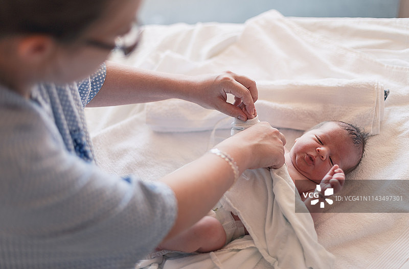 更换新生婴儿的尿布图片素材